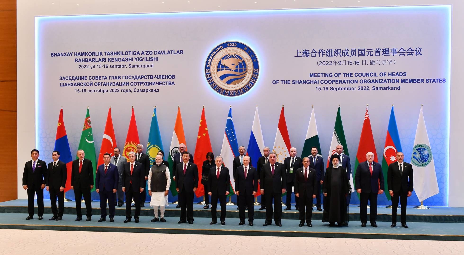 Alt-text: SCO heads of state pose in front of a wall-sized meeting banner.